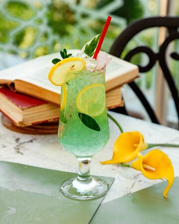 green lemon cocktail with ice and lemon slicesの写真素材