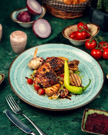 grilled chicken legs served with grilled vegetables and fresh pepperの写真素材