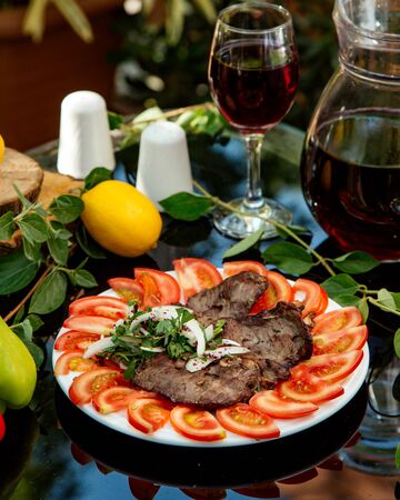 marinated beef served with tomato slices, onion and corianderの写真素材