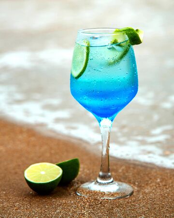 blue drink with lime on sea shoreの写真素材