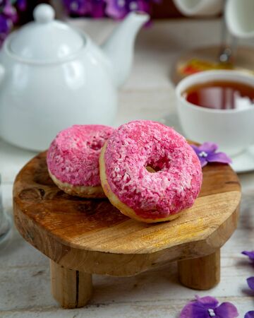 donuts topped with meringue and a cup of black teaの写真素材