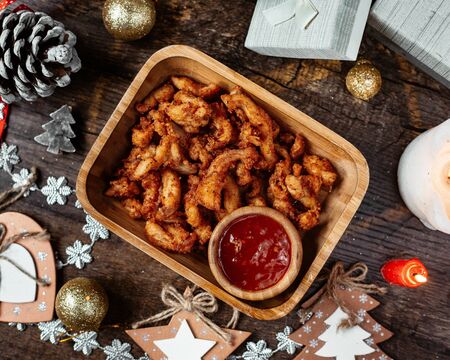 a serving of crispy fried snack served with red pepper sauce