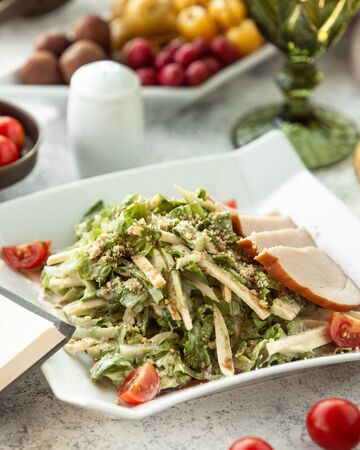 caesar salad with smoked turkey slicesの写真素材