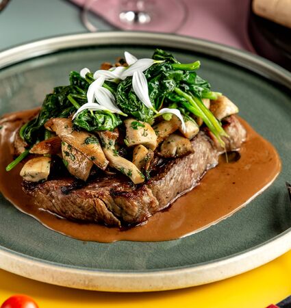 beef steak garnished with sauteed mushroom and spinachの写真素材