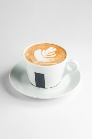 a cup of latte with latte art in white backgroundの写真素材