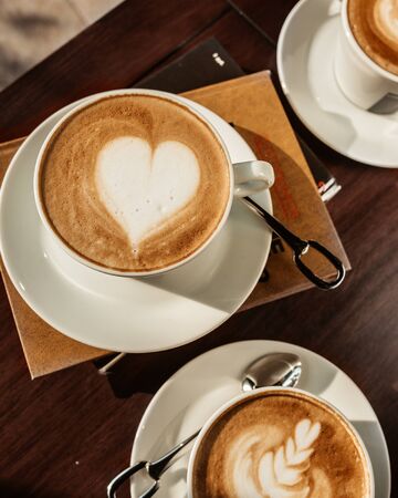 top view of three cups of coffee with latte artsの写真素材