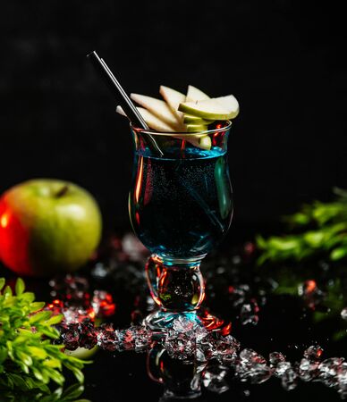 blue cocktail with apple slicesの写真素材