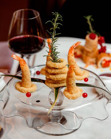 fried onion rings and shrimps with red wineの写真素材