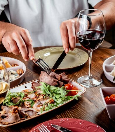 meat carpaccio with vegetables and red wineの写真素材