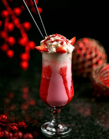 strawberry milkshake with ice on the tableの写真素材