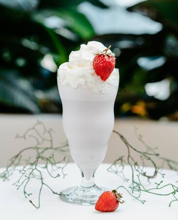 white milkshake with strawberry on the tableの写真素材