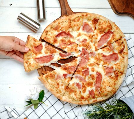 pizza with ham on the tableの写真素材