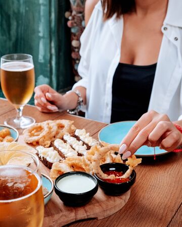 girl eating a beer set and drinking beer with frothの写真素材