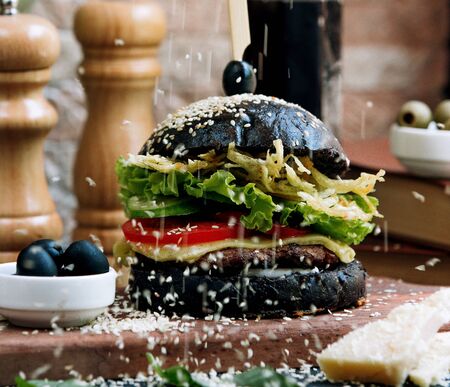 black cheeseburger topped with sesame seedsの写真素材