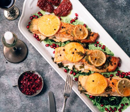 fried fish fillet with lemon slice and pomegranateの写真素材