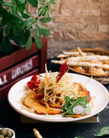 fried pancakes with tomato and herbsの写真素材