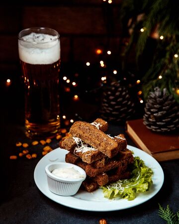 garlic toasts with sauce and glass of beerの写真素材