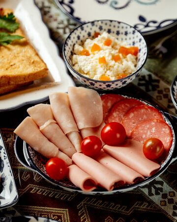 ham and sausage slices with tomatoesの写真素材