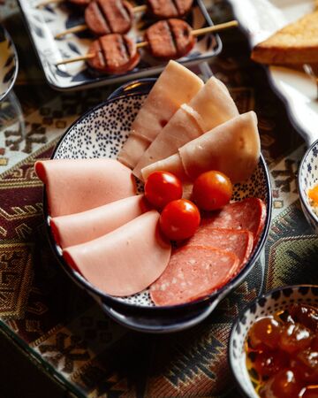 ham and sausage slices with tomatoesの写真素材