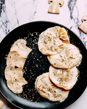 pancakes with sauce on top and mushroom slicesの写真素材
