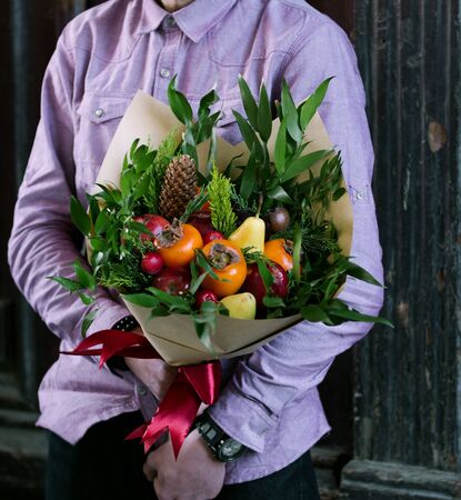 a person holding fruit bouquetの写真素材