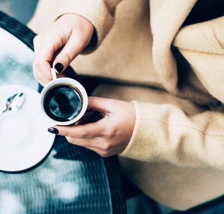 a person holding a cup of coffeeの写真素材