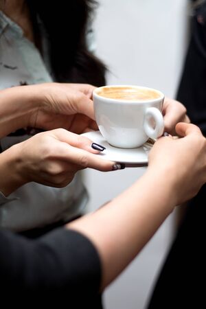 a person holds a cup of cappuccinoの写真素材