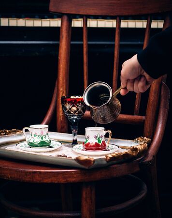 a person pours coffee in cupの写真素材