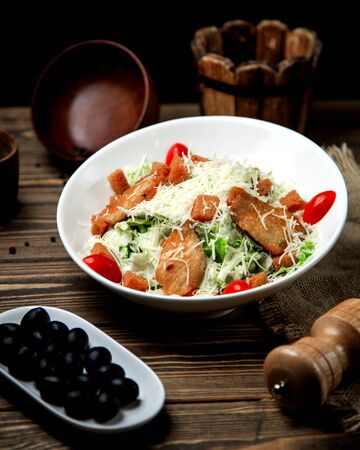 caesar salad with chicken lettuce cherry tomato and grated cheeseの写真素材
