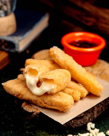 cheese sticks in batter on a wooden hempの写真素材