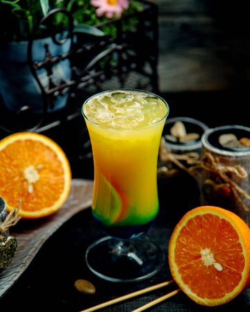 orange cocktail with ice on the tableの写真素材