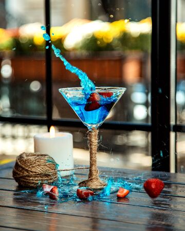 strawberries splashed into a martini glassの写真素材