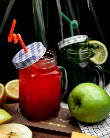 refreshments in glass cans with lemons and applesの写真素材