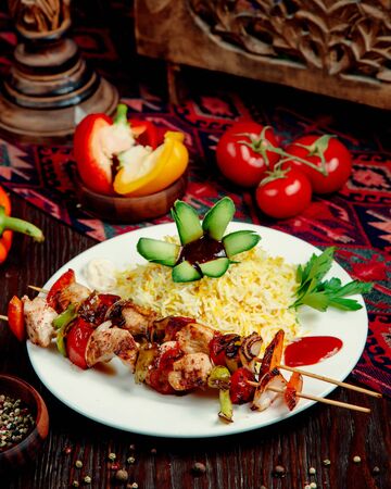 rice with chicken and vegetables on a stickの写真素材