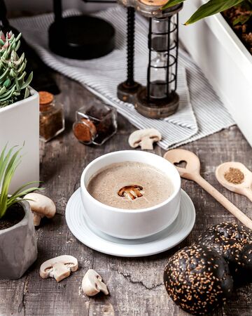 a bowl of mushroom soup served with black bread bunsの写真素材