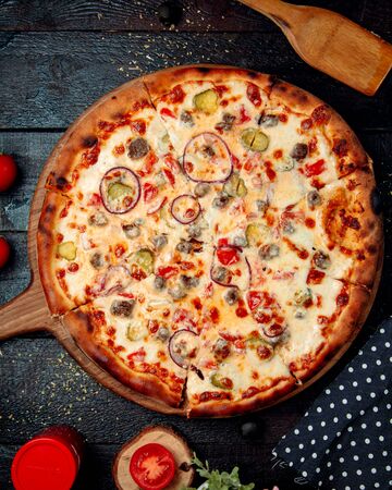 crispy pizza with meat onion and tomatoの写真素材