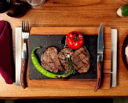 top view of beef steaks served with grilled tomato andの写真素材