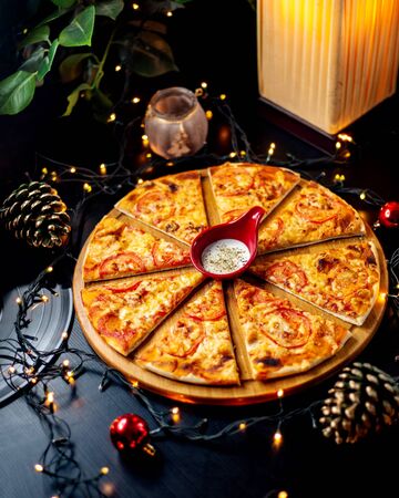 sliced chicken pizza served with yogurt sauce with herbsの写真素材