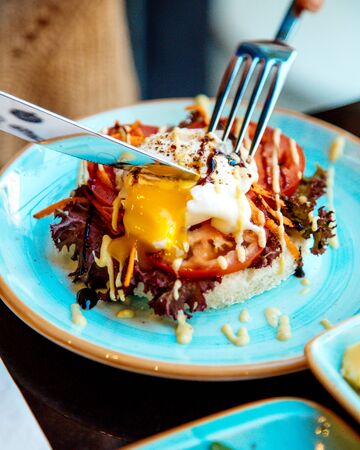 sliced poached egg on tomato and crisp breadの写真素材