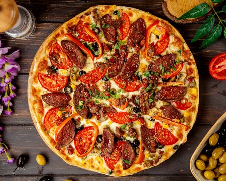 top view of sausage pizza with tomato red bell pepperの写真素材
