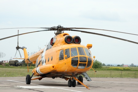The yellow helicopter costs on an airfieldのeditorial素材