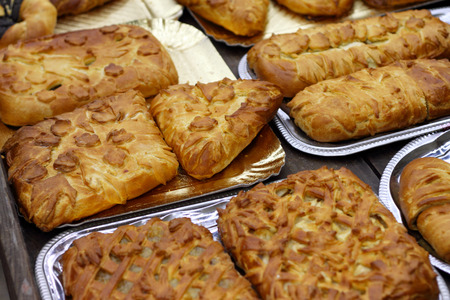 Various kinds of pies lay on trays.