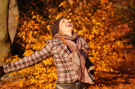 Young woman enjoying sunny day in autumn in the park