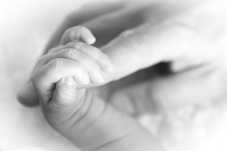 Closeup at a tiny hand of a newbornの写真素材