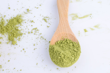 green powder on spoon isolated on white background