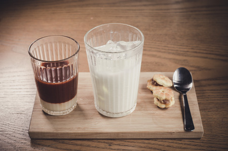Thai Tea comes in a milk glass of cold , and syrup on a wooden tableの写真素材