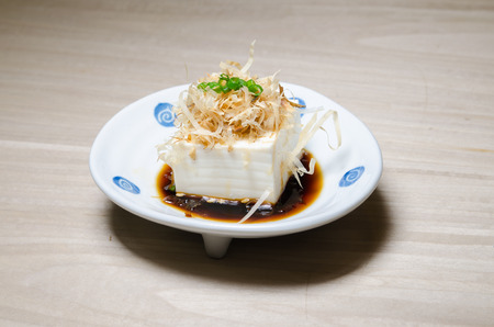 Japanese tofu, Japanese soft cold tofu with sauce in a dish on dining tableの写真素材