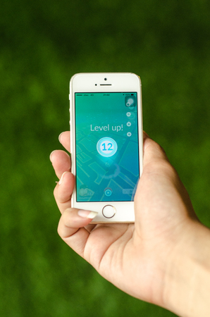 Bangkok, Thailand - August 9, 2016 : A plays in one hand showing its screen level up, with Pokemon Go applicationのeditorial素材