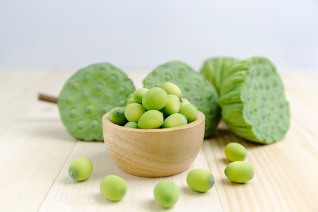 Lotus seed pod in wooden bowl with wood floorの写真素材
