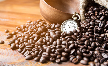 Clock in break time and Coffee beans with bag on the wood floorの写真素材
